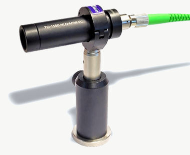 SHG-Unit, Mini-FC version: slim black tube labelled TD-1550-NLO-MINI-FC with a green fiber connector, mounted on a post.
