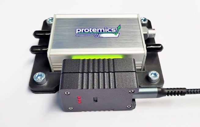Photograph of the TS Companion with the black Remote Control Plug attached to its Sub-D connector and a USB cable.